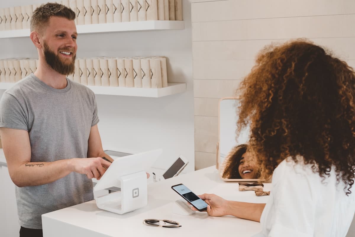A small business owner and customer at the front counter of a shop