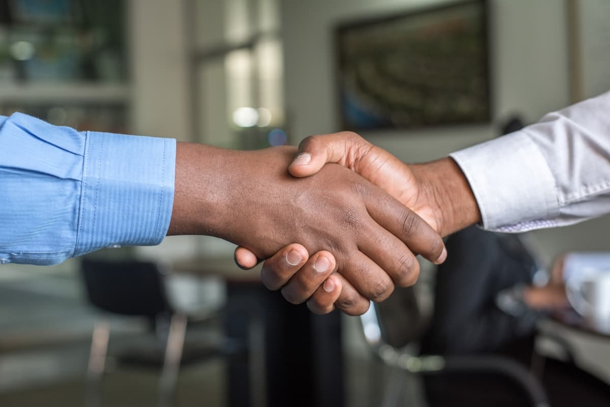 Two professionals shaking hands over a desk